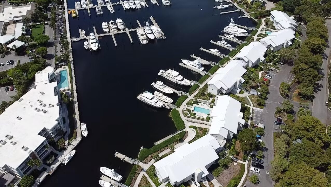Marina Village Condominium Phase I and II Aerial view of a marina with yachts docked alongside white buildings.